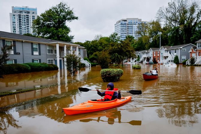 Candice Ocvil, left, and Jibri Tolen, right, row through flood waters in Atlanta on Friday.