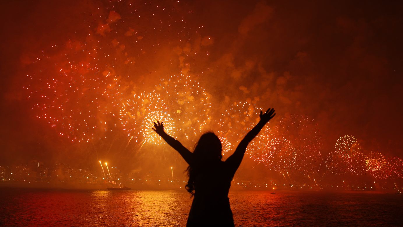 A woman watches fireworks burst above Copacabana Beach in Rio de Janeiro.