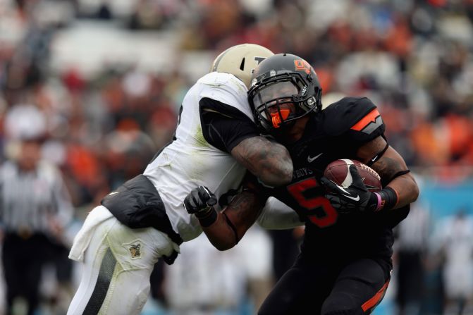 Josh Stewart of the Oklahoma State Cowboys is tackled by Josh Johnson of the Purdue Boilermakers on January 1