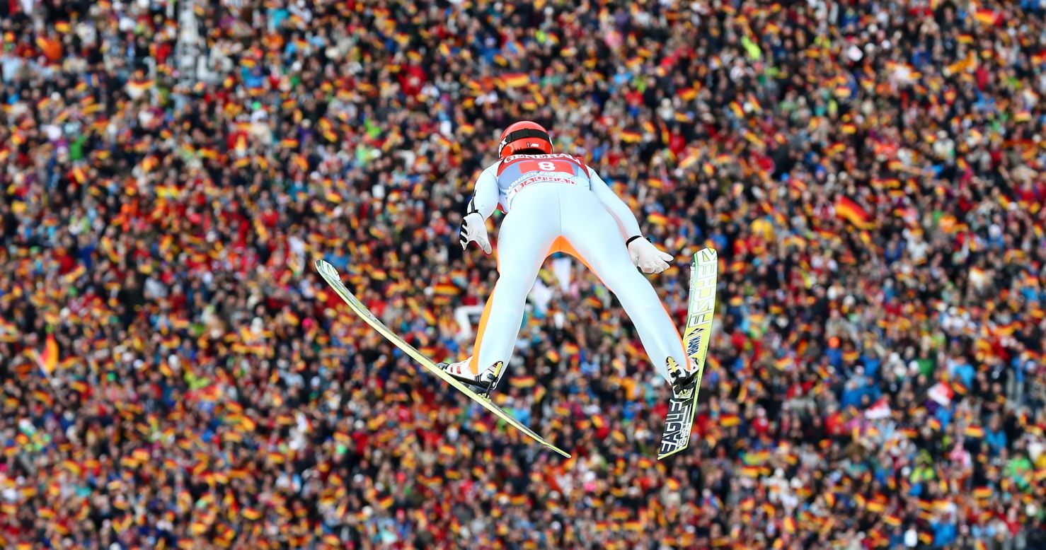 Fans below wave German flags as countryman Andreas Wank competes during the final round on January 1.