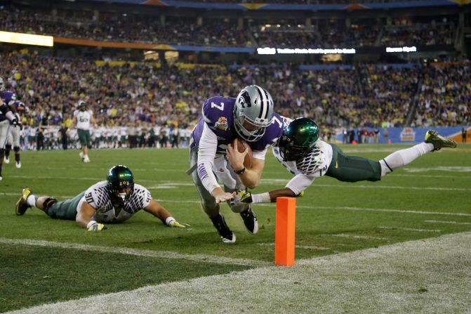 Collin Klein of the Kansas State Wildcats scores a second quarter touchdown as Ifo Ekpre-Olomu of the Oregon Ducks tries to stop him during the Tostitos Fiesta Bowl at University of Phoenix Stadium on Thursday, January 3, in Glendale, Arizona.