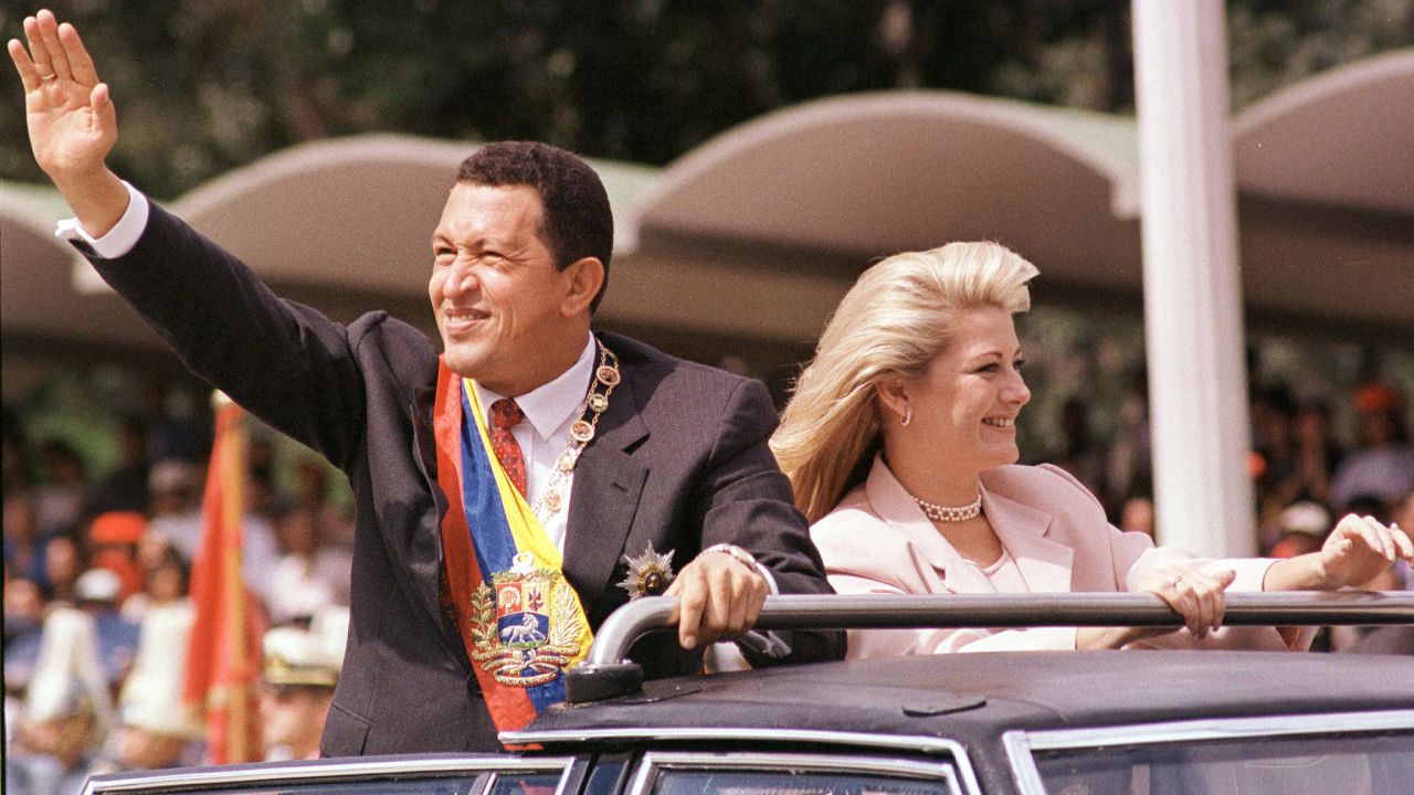 President Chavez greets supporters with his then-wife, Marisabel Rodriguez de Chavez, beside him as he arrives to preside over a parade in his honor on February 4, 1999, in Caracas. Chavez was sworn in as president on February 2.