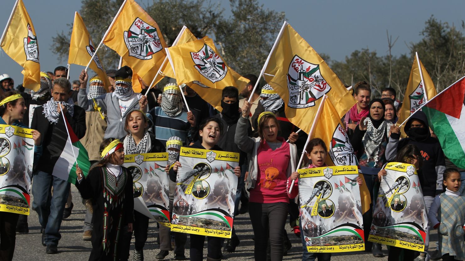 Palestinian protesters carry Fatah party flags during a march organised by residents of the West Bank village Nabi Saleh.