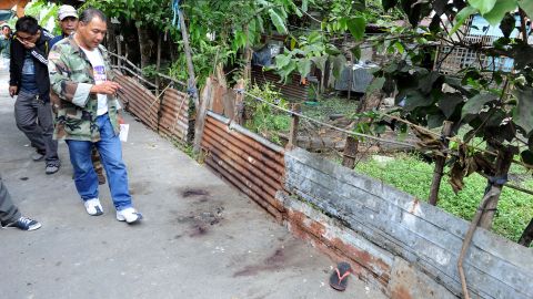 Police investigate the scene of a gun battle in Kawit, about 40 km south of Manila on January 4, 2013.