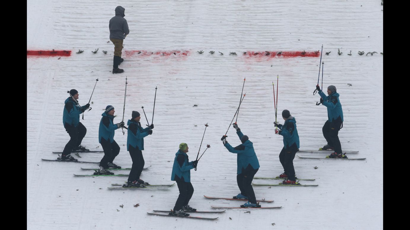 Maintenance crew members gesture as they prepare the landing zone with their skis on January 4.