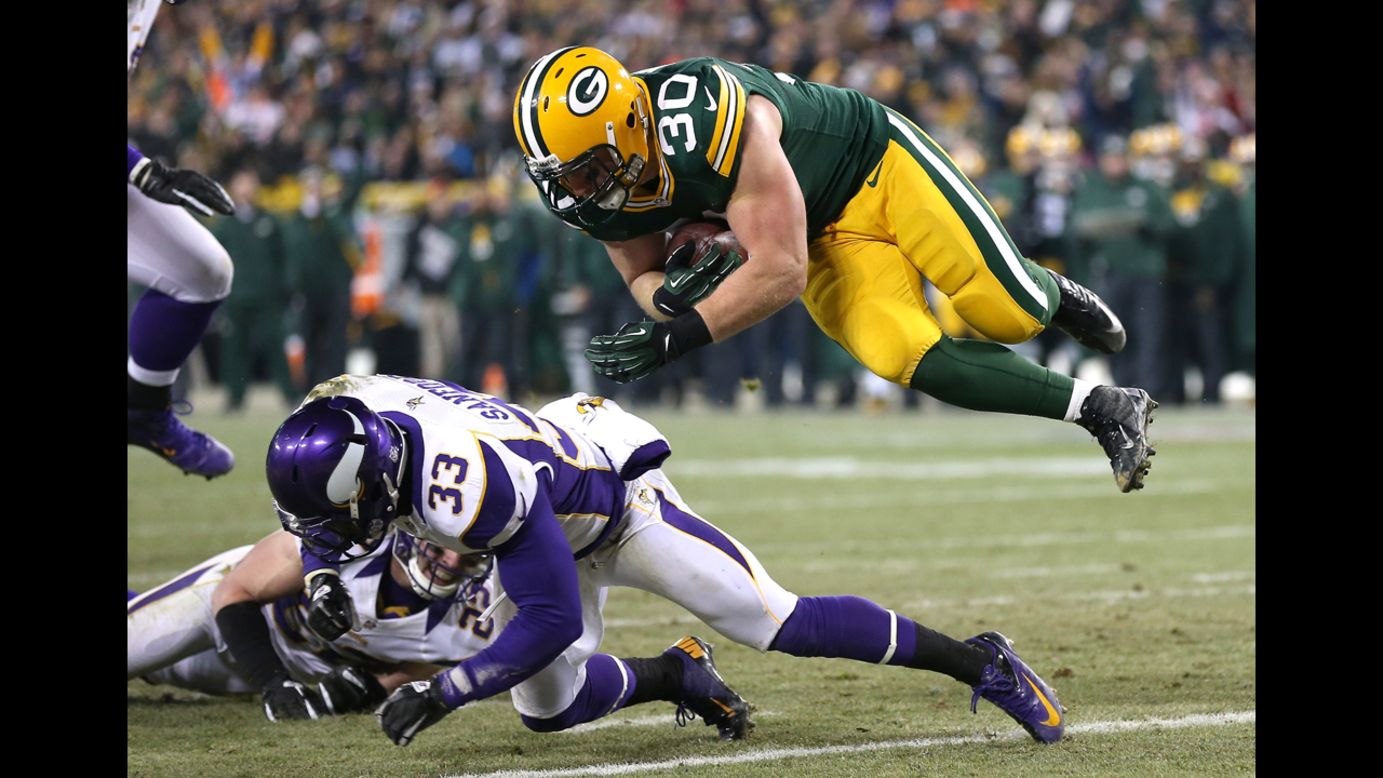 John Kuhn sails over Vikings safety Jamarca Sanford to score on a nine-yard touchdown catch and run.