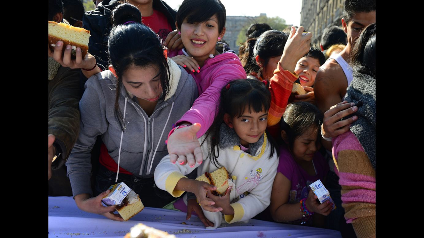 People gather to get a piece of the bread on Thursday in Mexico City.