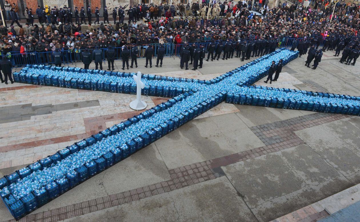 Romanian officers guard bottles containing holy water to be distributed after the service in Constanta City on Sunday.