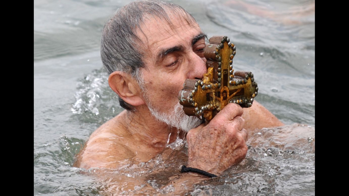 A Greek Orthodox swimmer kisses the wooden cross he retrieved from the Golden Horn in Istanbul on Sunday.