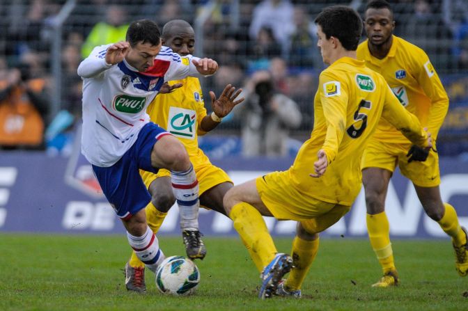 Lyon's French midfielder Steed Malbranque vies with Epinal's French defender Wilfried Rother as the home team get stuck into the top division side.