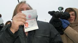 French actor Gerard Depardieu, who has threatened to quit his homeland to avoid higher taxes, shows off his new Russian passport on January 6, 2013 at Mordovia airport in Saransk where he has been offered residence in this central Russia region known.