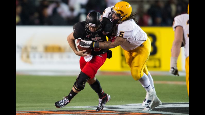 Arkansas State quarterback Ryan Aplin tries to elude a tackle by Kent State defensive lineman Dana Brown Jr. on January 6.