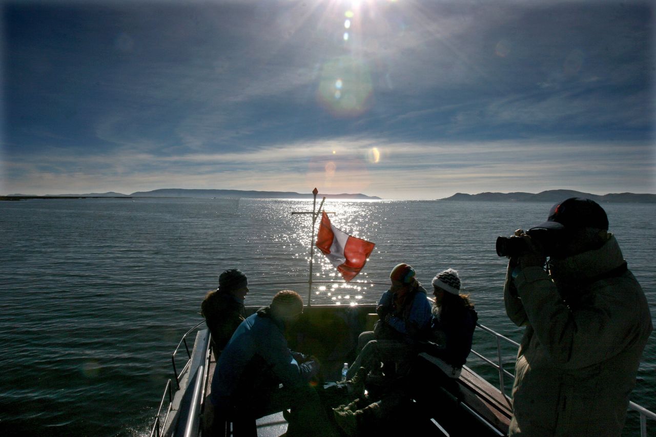 Tourists chatter and snap pictures aboard a boat on the Peruvian side of Lake Titicaca.