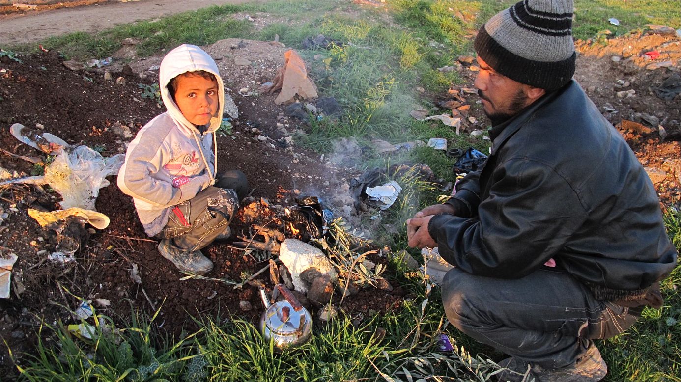 Abo Ahmad lit up plastics for warmth with his child.