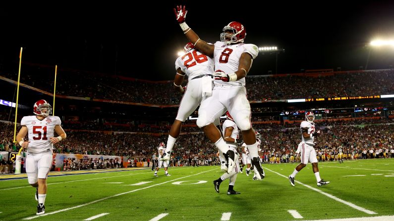 Landon Collins of the Alabama Crimson Tide, left, and Jeoffrey Pagan celebrate after pinning the Notre Dame Fighting Irish deep in their own territory.