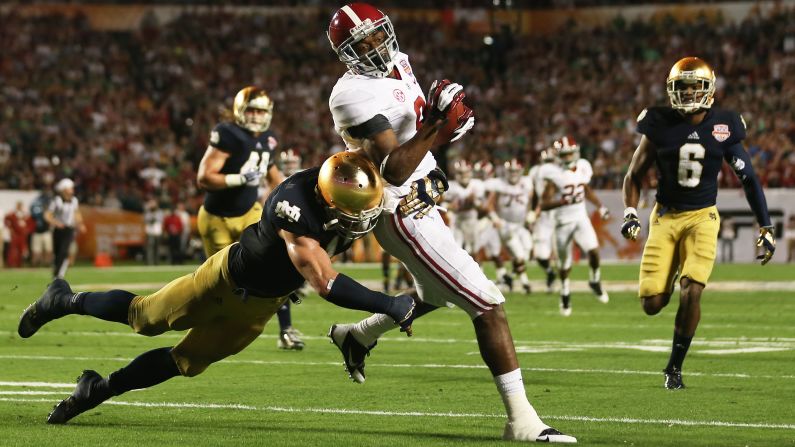 Zeke Motta of Notre Dame tackles Alabama's Amari Cooper.