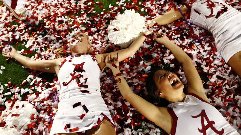 Crimson Tide cheerleaders celebrate on the field after the game.