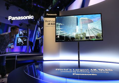 An attendee looks at a display of the Panasonic 4K OLED 56' television at the company's booth in the Las Vegas Convention Center.