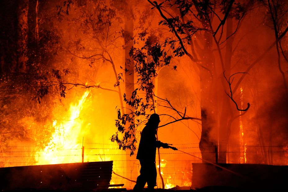 A firefighter battles the flames of the Dean's Gully fire at a property near the town of Wandandian in New South Wales, on January 8. 