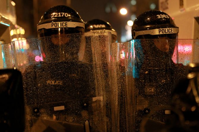 Police dressed in riot gear protect the City Hall as loyalist protesters gather on Monday.