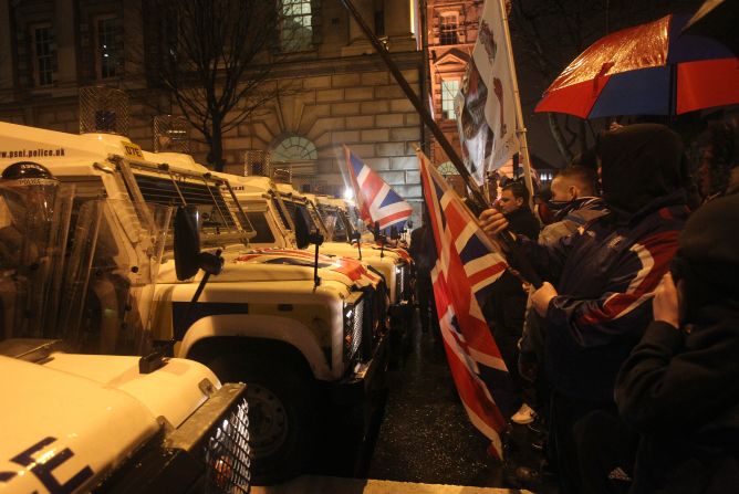 Loyalist protesters confront police as they gather at Belfast City Hall during a City Council meeting in Belfast, Northern Ireland, on Monday, January 7. Violence flared for the fifth consecutive night in Northern Ireland as pro-British demonstrators protested the council's decision to limit the number of days the British Union Jack flag can be flown above the City Hall.