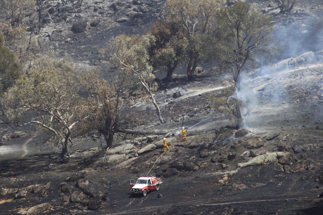 Fire fighters battle a grass fire in Oura, near Wagga Wagga in New South Wales on January 8, 2013. 