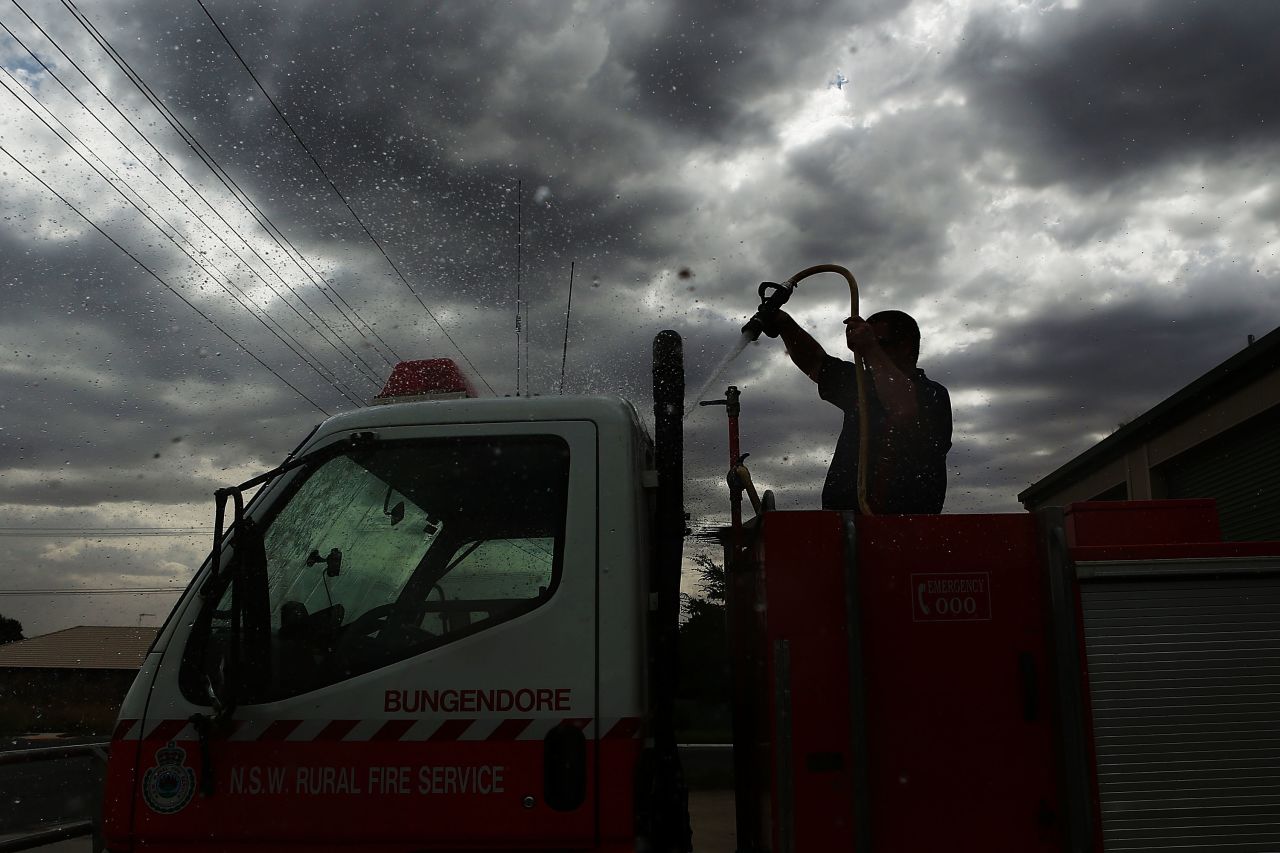 A volunteer Rural Fire Service member from Bungendore RFS washes down a emergency service vehicle on January 8, 2013 in Bungendore, Australia.