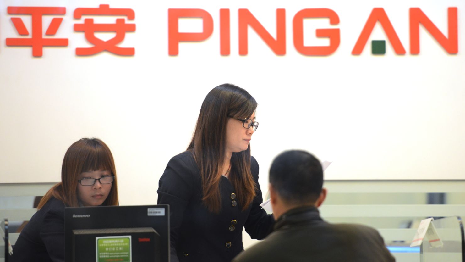 People are seen inside of a branch of Ping An Insurance in Shanghai on November 26, 2012. 