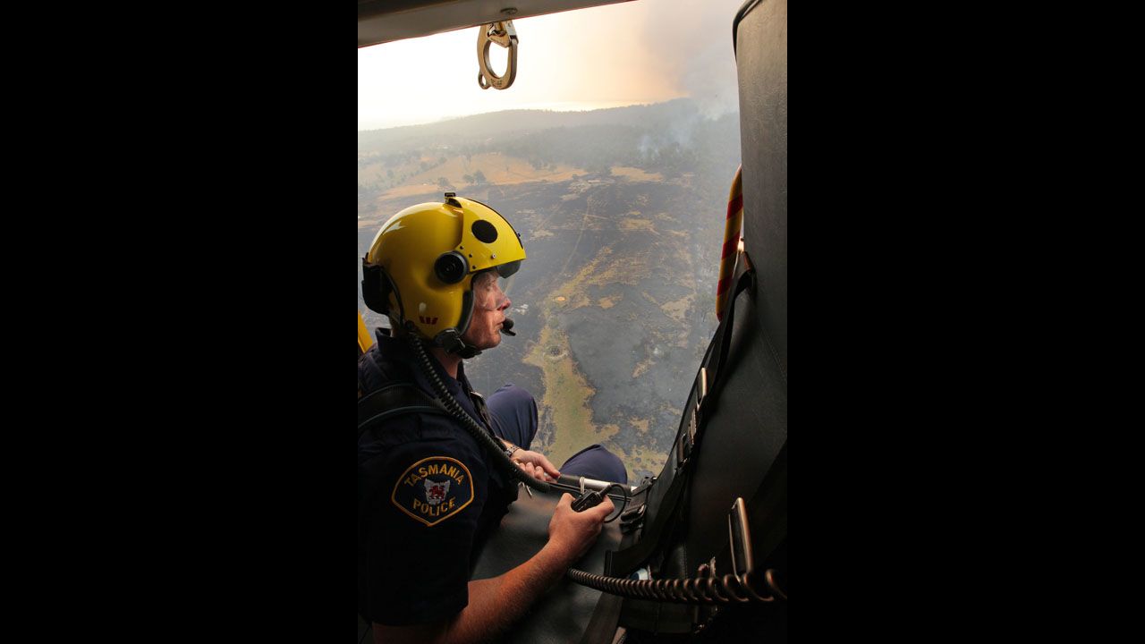 Sgt. Matthew Drumm, a police rescue helicopter crewman, surveys devastation in Dunalley after bush fires swept through this part of Tasmania.
