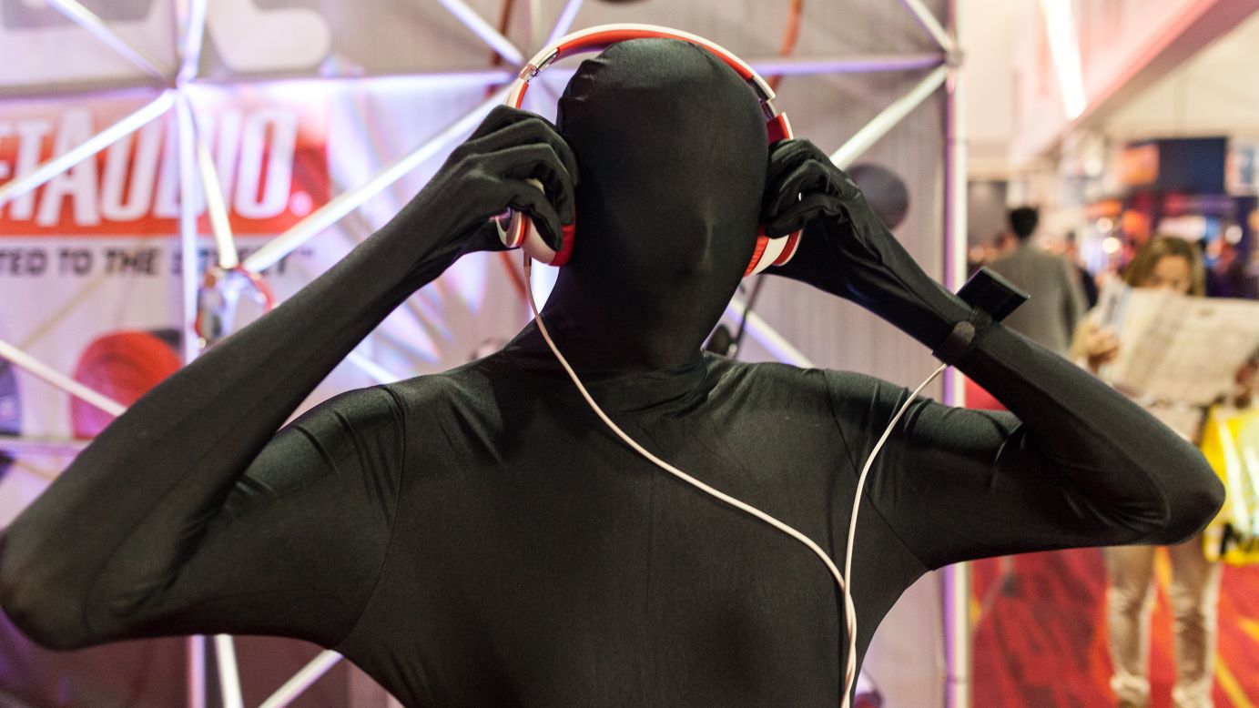 A man dressed in a full body suit wears headphones by MTX Audio.