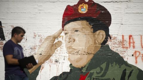 A man walks by a painting on a wall of Venezuelan President Hugo Chavez in Caracas on January 9.