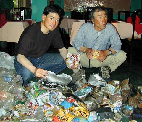 In this photograph taken in May 2001, Japanese mountaineer Ken Noguchi (L) and South Korean mountaineer Lee Sang-Bae (R) display  garbage collected from Mt. Everest during their cleaning expedition. They had brought back more than 1.7 tons of garbage from the trip. 