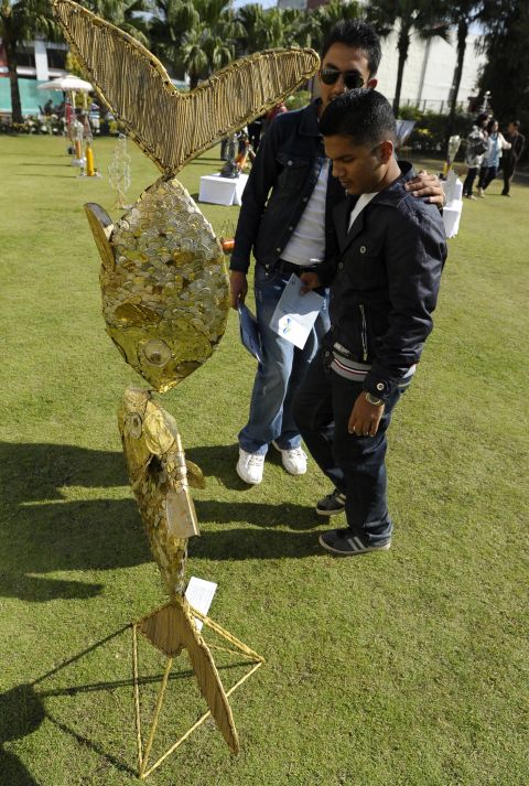 Visitors look at art made from trash collected on Mount Everest, commissioned for the "Mt. Everest 8848 Art Project" in Kathmandu on November 19, 2012.