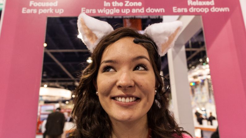 A woman demonstrates Necomimi Brainwave cat ears Wednesday.  According to the company, the ears read your brain waves to determine your mood and reflect it by wiggling, perking up or drooping down.
