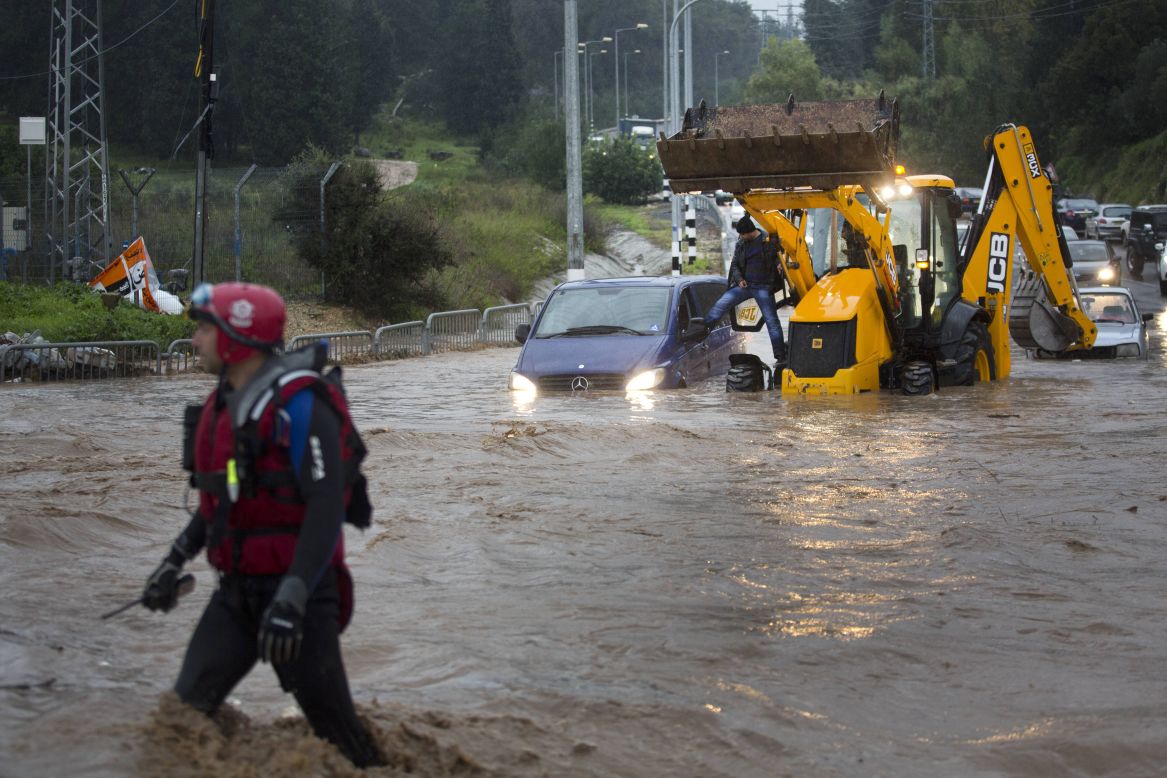Rescue team evacuates people trapped in their cars in a flooded road near the Israeli-Arab town of Kfar Qara, in central Israel.