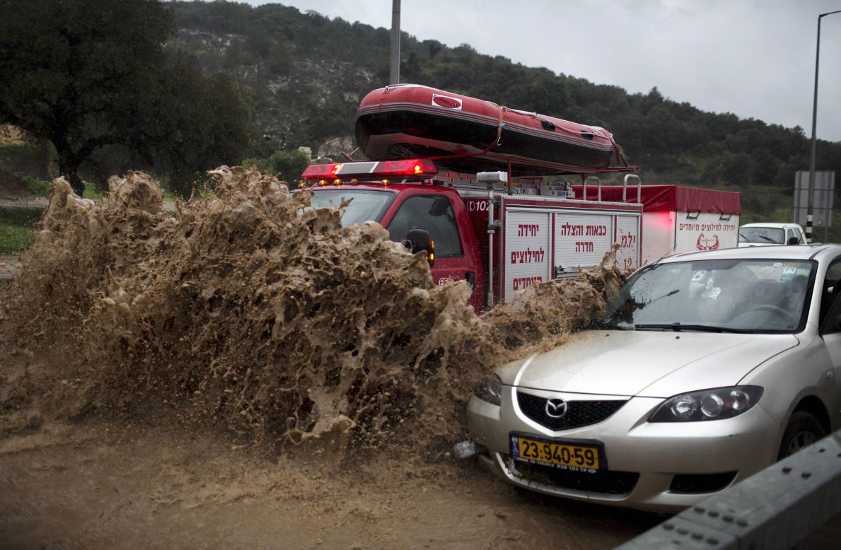A fireman's truck drives through a flooded road to rescue people trapped in their vehicles near the Israeli-Arab town of Kfar Qara, in central Israel. 