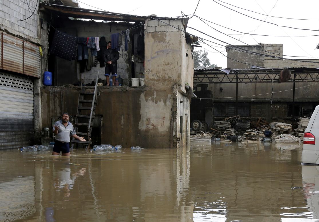 A man walks in a flooded yard as he comes out of his squat in the Lebanese capital Beirut, on January 7.