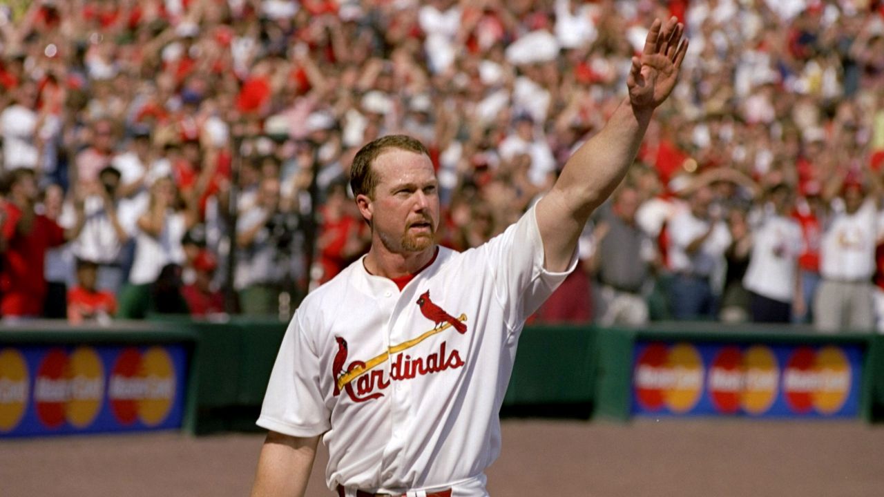 Mark McGwire of the St. Louis Cardinals waves to fans after hitting his 70th home run of the 1998 season during a game against the Montreal Expos. He broke the single-season home-run record in a race against rival Sammy Sosa.