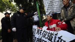 Protesters holding banners in support of greater media freedom confront police in Guangzhou on January 10.