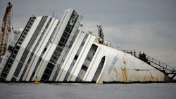 The Costa Concordia cruise ship lays aground near the port on January 9, 2013 on the Italian island of Giglio. A year on from the Costa Concordia tragedy in which 32 people lost their lives, the giant cruise ship still lies keeled over on an Italian island and its captain Francesco Schettino has become a global figure of mockery.  AFP PHOTO / FILIPPO MONTEFORTE        (Photo credit should read FILIPPO MONTEFORTE/AFP/Getty Images)
