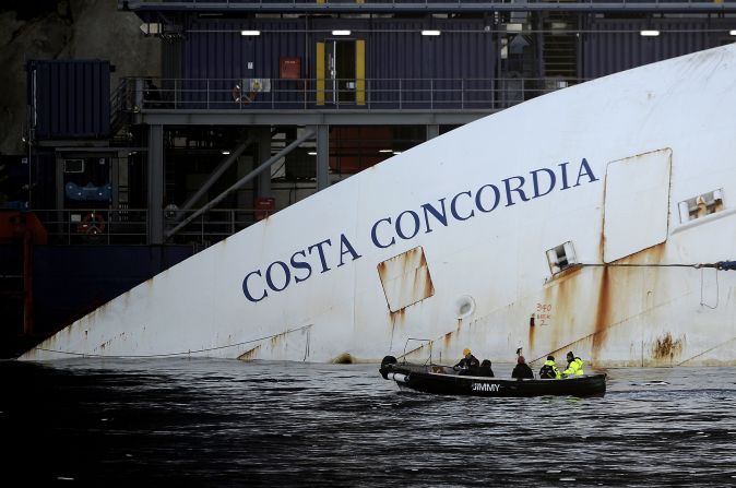 Workers in a small boat pass by the Costa Concordia on Monday, January 7. <a href="index.php?page=&url=http%3A%2F%2Fwww.cnn.com%2F2012%2F01%2F14%2Feurope%2Fgallery%2Fitaly-ship%2Findex.html">See photos from the shipwreck in 2012.</a>
