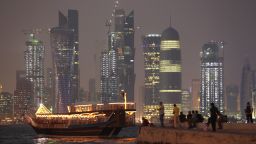 A boat arrives at a jetty in front of the sparkling Doha skyline.
