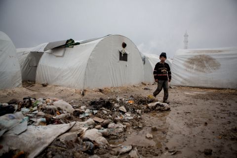 A Syrian boy walks near rubbish next to tents at a refugee camp near the northern city of Azaz on the Syria-Turkey border, on January 8.