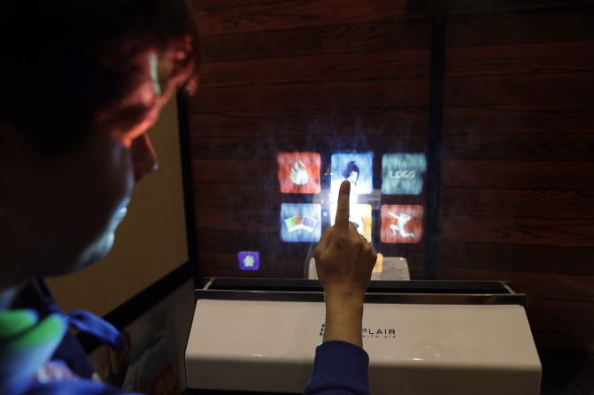 An attendee uses a water-based touch screen computer monitor created by Displair on January 10.
