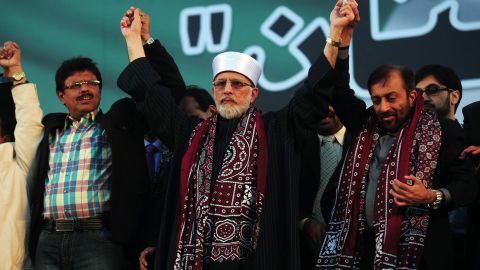 Pakistani Muslim scholar Tahir ul Qadri joins hands during a public rally in Karachi on January 1, 2013.