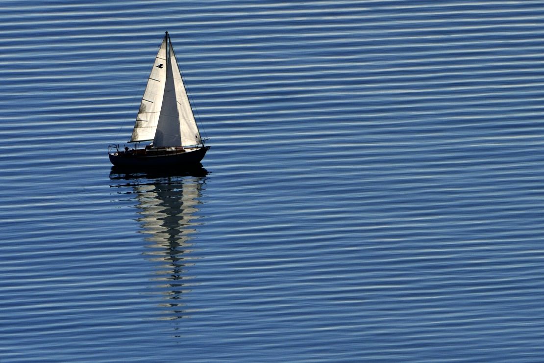 A boat sails across the peaceful waters of Lake Geneva.