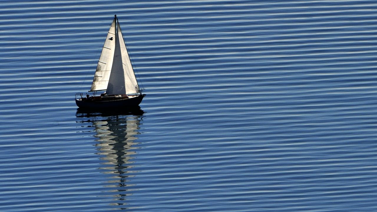 A boat sails across the peaceful waters of Lake Geneva.