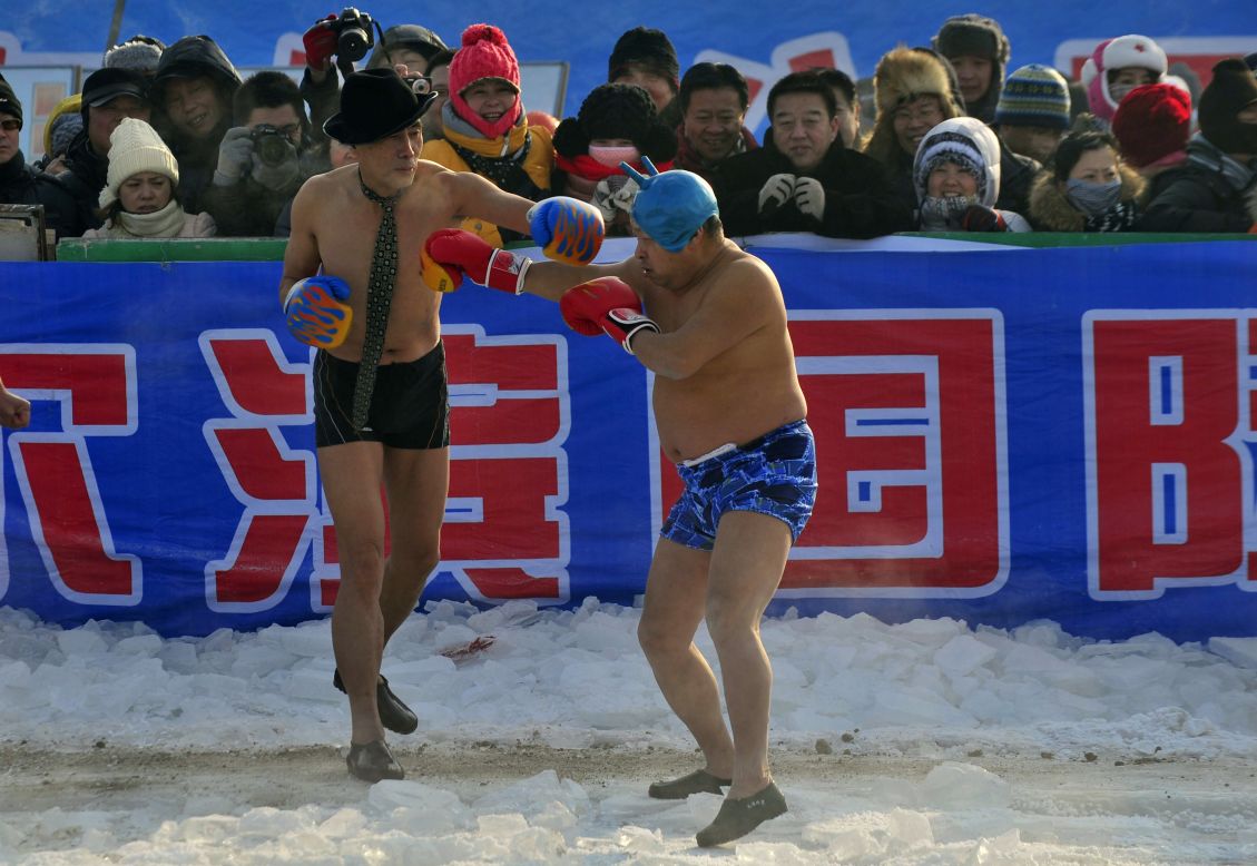 Winter swimming fans perform a boxing match on the frozen Songhua River during the Harbin festival, on Friday, January 11.