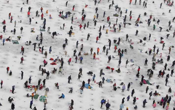 Anglers cast lines through holes into a frozen river during an ice fishing competition at the Hwacheon Sancheoneo Ice Festival on Saturday, January 5 in Hwacheon-gun, South Korea. The event attracts thousands of visitors every year.