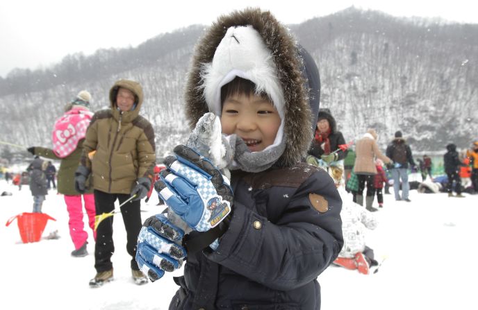 A child displays a fish caught during the ice fishing competition at the Hwacheon Sancheoneo festival.